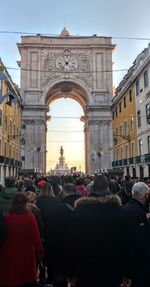 Crowd in city against sky