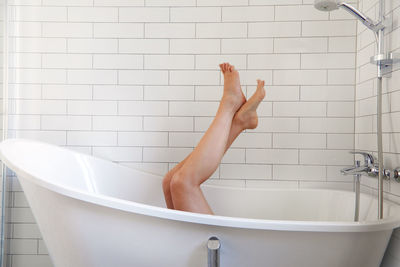 Midsection of woman in bathroom at home