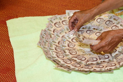 Close-up of man arranging paper currency