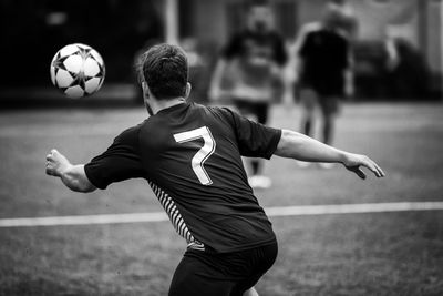 Rear view of soccer player playing field