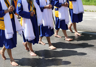 Low section of people walking on street