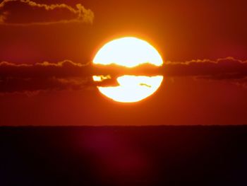 Silhouette landscape against sea during sunset