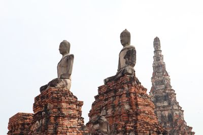 Low angle view of statue against historic building against clear sky