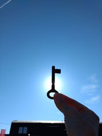 Low angle view of person hand against clear blue sky