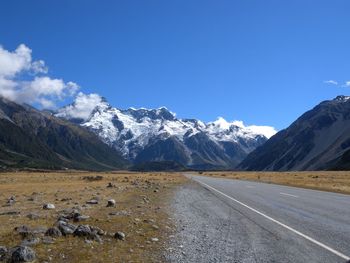 Scenic view of snowcapped mountains against blue sky