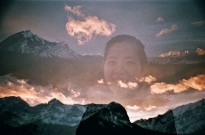 Portrait of smiling man against mountains during sunset