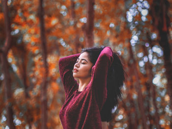 Portrait of beautiful young woman in autumn leaves