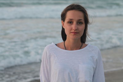 Portrait of young woman standing on shore at beach