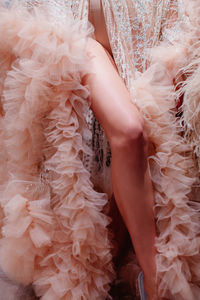 Fashion model dressed in a fluffy long pink haute couture boudoir dress. vertical fashion shot