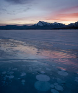 Scenic view of snowcapped mountains against sky during sunset
