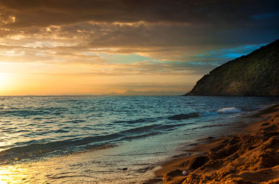 Scenic view of beach against sky during sunset