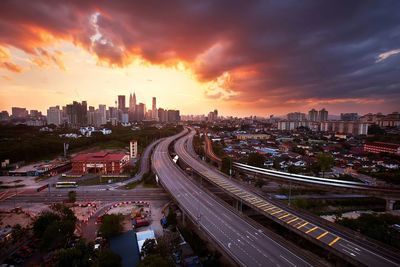 High angle view of city street against dramatic sky during sunset