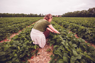 Woman standing on field against sky