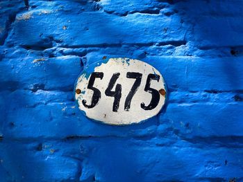 Close-up of numbers on old blue wall