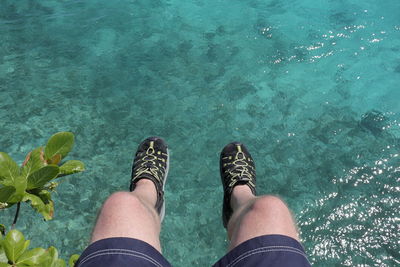 Low section of woman standing in swimming pool