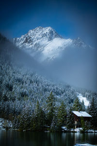 Scenic view of lake by snowcapped mountains against sky