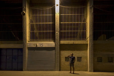 Full length of man standing on illuminated building at night