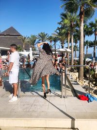 People at swimming pool against sky