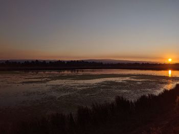 Scenic view of sea against clear sky during sunset