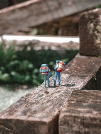 Close-up of figurine on wood against wall