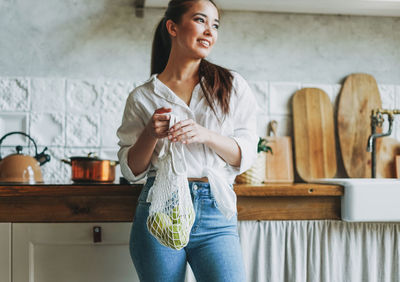 Smiling young woman standing at home