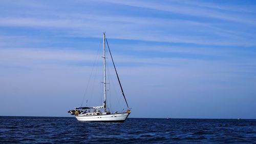 Sailboat sailing on sea against sky