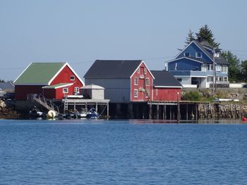 Houses by sea against clear sky