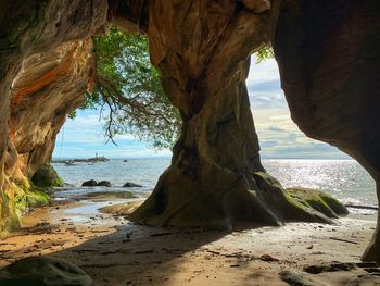 Rock formation on beach against sky