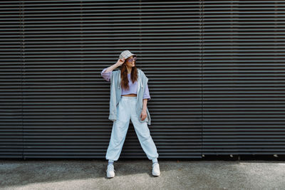 Caucasian girl dancer standing front of the wall. looking away. isolated background.