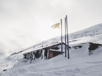 View of people skiing on snowcapped mountain against sky