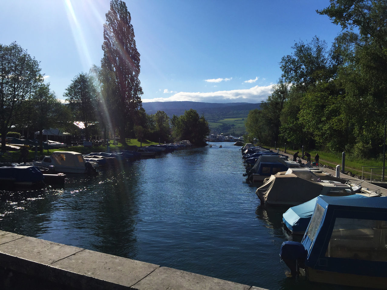 BOATS MOORED IN RIVER AGAINST SKY