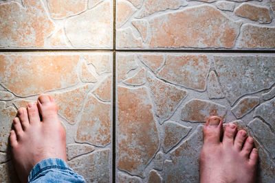 Low section of man on tiled floor