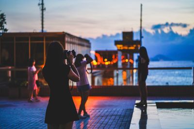 People photographing against sky during sunset