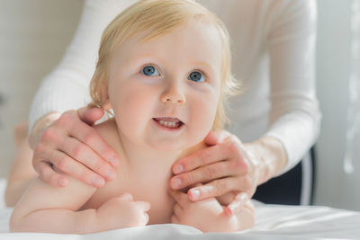 Mom gives her baby a shoulder and back massage. close-up.