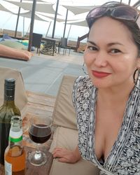 Portrait of smiling woman with drink on table