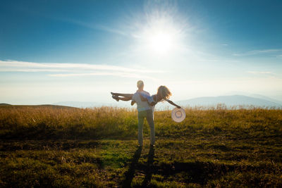 Man standing on field against bright sun