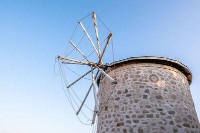 Low angle view of traditional windmill against clear sky