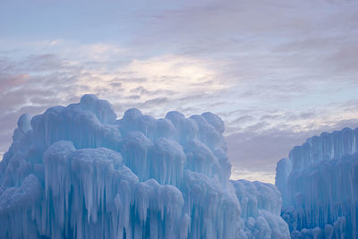 Panoramic view of ice castles against sky during winter