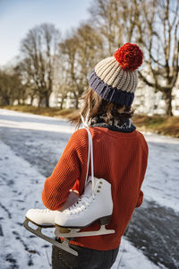 Woman on canal carrying ice skates