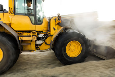 Man operating bulldozer at industrial site