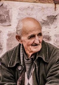 Smiling senior man looking away against wall