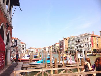 People on piers over grand canal against sky