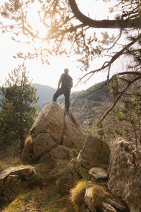 Man standing on rock against sky