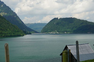 Scenic view of lake by mountains against sky