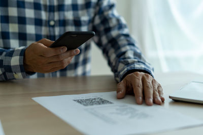 Midsection of man using mobile phone