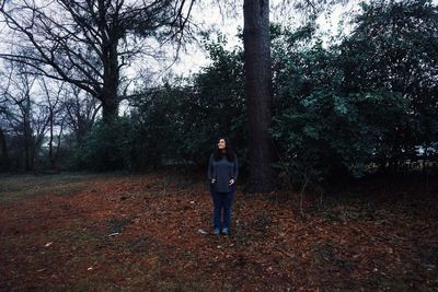 Smiling young woman standing in forest