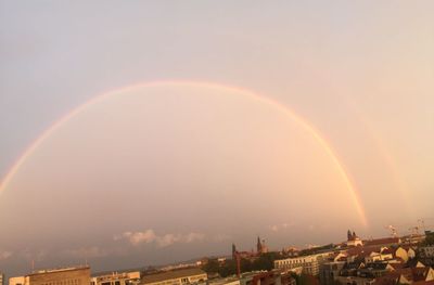 Rainbow over city against clear sky