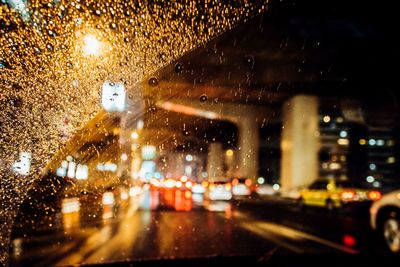 Road traffic seen through wet windshield 