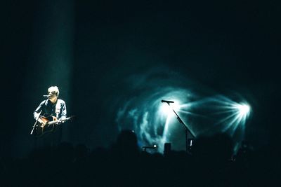 Man on illuminated stage at night