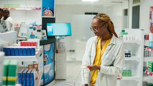 Side view of man using mobile phone while standing in laboratory